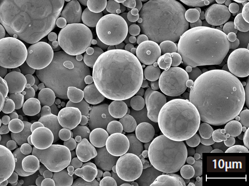 銅合金粉末の走査型電子顕微鏡(SEM)画像。球状の粒子が均一に分布している。スケールバー10μm。